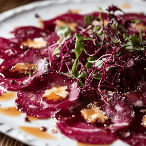 Die rote Bete ist nicht nur ein wahres Superfood, sondern auch ein kulinarischer Genuss, der sich perfekt für eine Vielzahl von Gerichten eignet. Ihre tiefrote Farbe und der erdige Geschmack machen sie zu einer außergewöhnlichen Zutat, die in der modernen Küche immer mehr an Bedeutung gewinnt. In diesem Artikel stellen wir Ihnen ein köstliches Rezept für Rote Bete-Carpaccio mit Ziegenkäse und Walnüssen vor. Dieses Gericht vereint die erdigen Aromen der Roten Bete mit dem würzigen Geschmack des Ziegenkäses und der Knusprigkeit der Walnüsse. Ideal als Vorspeise oder leichtes Hauptgericht, wird es Ihre Gäste beeindrucken und Ihre Sinne verwöhnen.